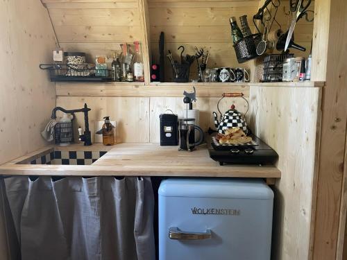 una pequeña cocina con encimera y nevera en Fairytale tinyhouse near the sea - Häxans hus, en Gothem