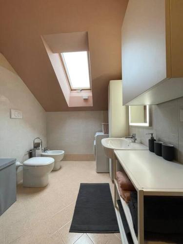 Lacchiarella的住宿－appartamento vistaverde，一间带两个盥洗盆、卫生间和天窗的浴室。
