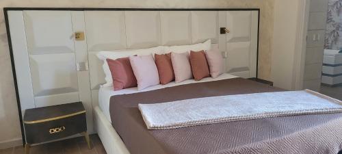 a bedroom with a bed with pink and white pillows at Villa Nasti Luxury Bed Taurasi Room in Nocera Inferiore