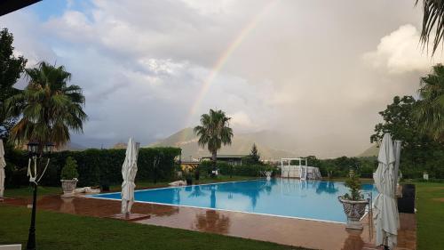 a rainbow over a swimming pool with a rainbow at Villa Nasti Luxury Bed Taurasi Room in Nocera Inferiore