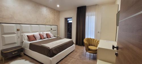 ein Schlafzimmer mit einem Bett, einem Tisch und einem Stuhl in der Unterkunft Villa Nasti Luxury Bed Taurasi Room in Nocera Inferiore