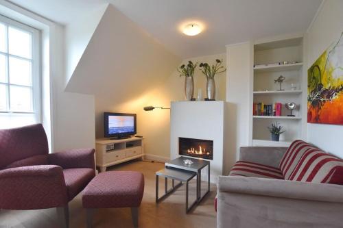 ein Wohnzimmer mit einem Sofa und einem Kamin in der Unterkunft Haus Magnus, App 4 in Wenningstedt-Braderup