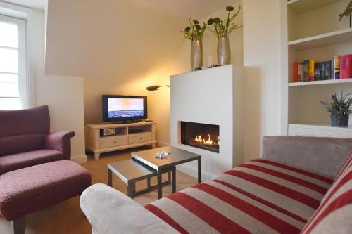ein Wohnzimmer mit einem Sofa und einem Kamin in der Unterkunft Haus Magnus, App 4 in Wenningstedt-Braderup