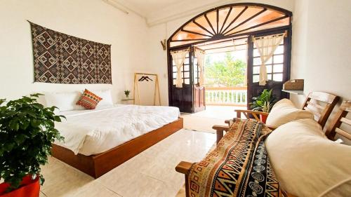 een slaapkamer met 2 bedden en een raam bij Maidi Homestay Mui Ne in Mũi Né