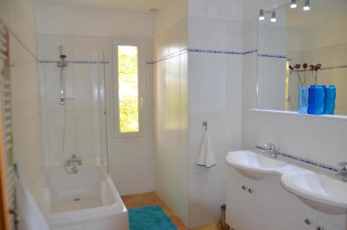 La salle de bains blanche est pourvue d'une douche, d'un lavabo et d'une baignoire. dans l'établissement Villa Cabasse, à Cabasse