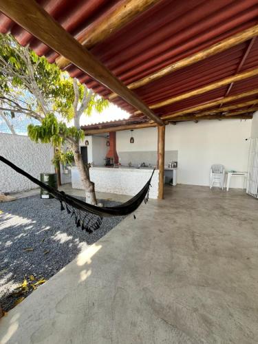 - un hamac sur la terrasse avec une table et des chaises dans l'établissement Beach House Guriri - Casa de temporada, à São Mateus