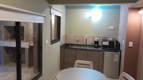 a small kitchen with a table and a microwave at Acacias Mina Clavero in Mina Clavero