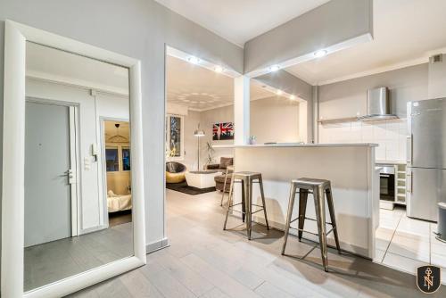 a kitchen with a counter and stools in a room at La Casa Verde - View of the racecourse & meadow in Caen