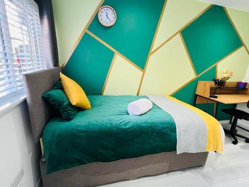 a bedroom with a bed with a clock on the wall at Stylish studio in Milton Keynes