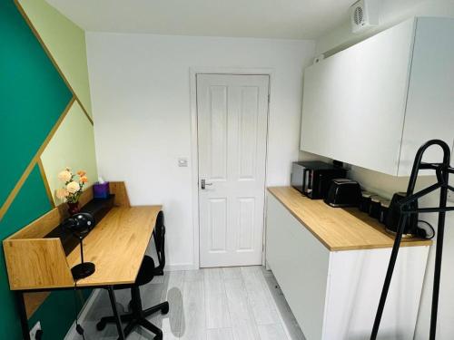 a kitchen with a table and a desk in a room at Stylish studio in Milton Keynes