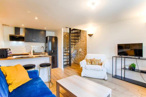 a living room with a blue couch and a kitchen at La Casa Elisa Family town house in Caen