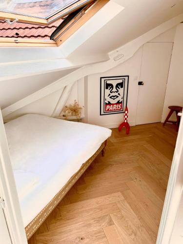 a bedroom with a bed in a attic at Maison d'architecte Triplex in Paris