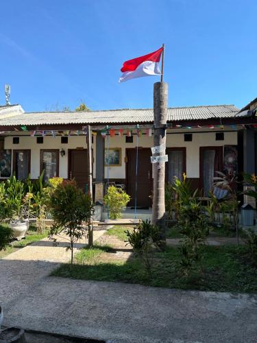 a house with a flag in front of it at Cozy Alfia Inn in Gili Trawangan