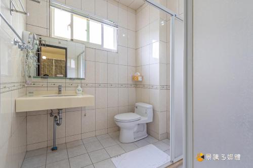 een badkamer met een toilet, een wastafel en een spiegel bij 苗栗公館聚福居民宿 in Miaoli