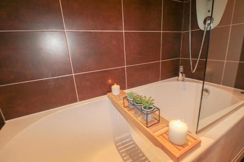 a bathroom with a bath tub with two candles at Simple 2 Bed in Central Dewsbury - Sleep 4 in Dewsbury