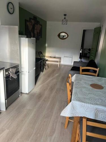 uma cozinha e sala de estar com uma mesa e um frigorífico em Appartement t2 refait à neuf plein centre em Langogne