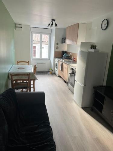 uma cozinha com uma mesa e um frigorífico branco em Appartement t2 refait à neuf plein centre em Langogne