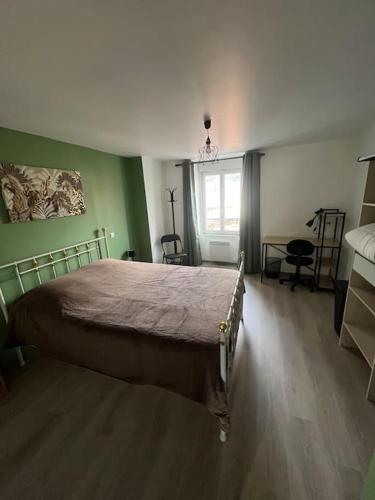 um quarto com uma cama num quarto com paredes verdes em Appartement t2 refait à neuf plein centre em Langogne