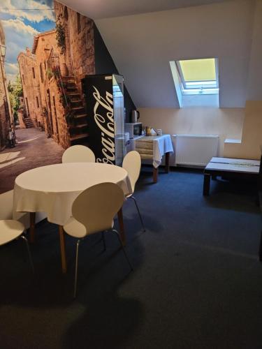 Cette chambre dispose d'une table, de chaises et d'un réfrigérateur. dans l'établissement Gangnam Hotel, à Ciągowice