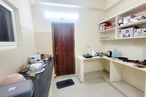 a kitchen with a wooden door in a room at Verizon stays 2BHK near Nizampet in Hyderabad