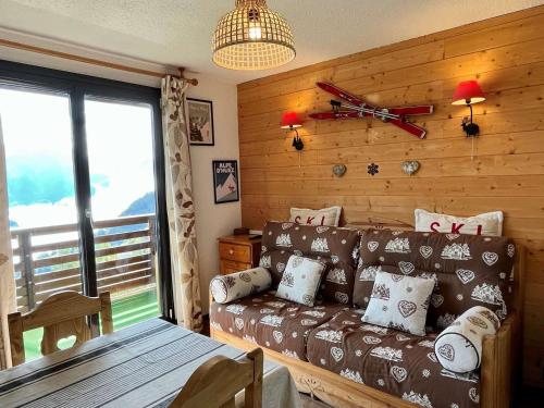 a living room with a couch and a large window at Appartement Huez, 2 pièces, 5 personnes - FR-1-405-346 in LʼHuez