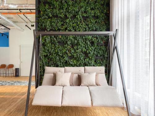 a white couch in front of a green wall at numa I Bloc Rooms & Apartments in Frankfurt/Main