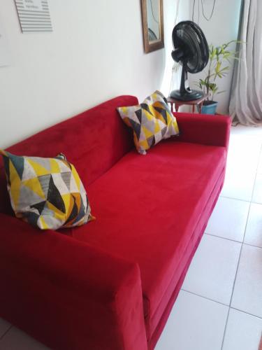 Un sofá rojo con dos almohadas. en CactusStudio en Salvador