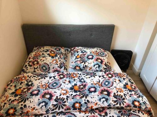 ein Bett mit einer Blumendecke und 2 Kissen in der Unterkunft Flat in Choisy Le Roy, 6 min from Paris in Choisy-le-Roi