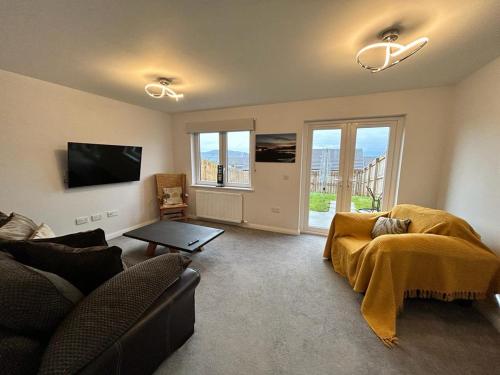 un salon avec un canapé et une télévision dans l'établissement Faillie, à Inverness