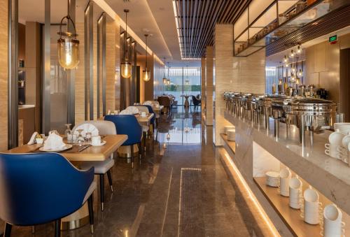 a restaurant with blue chairs and tables in a room at Boudl Al Rawdah in Buraydah