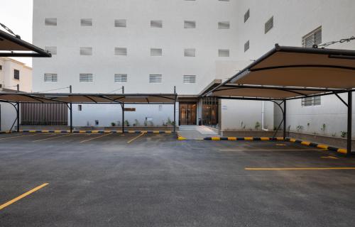 un parking avec un grand bâtiment blanc dans l'établissement Boudl Al Rawdah, à Buraydah
