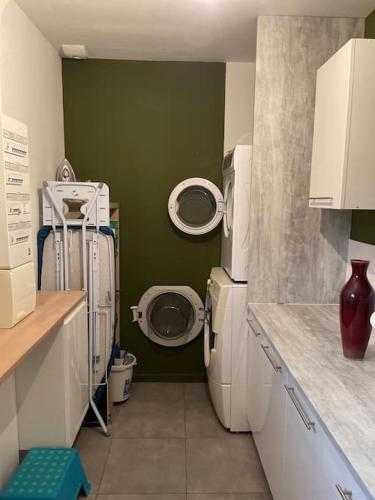 une salle de bain avec machine à laver et toilettes dans l'établissement La Montbourgeoise, à Montebourg