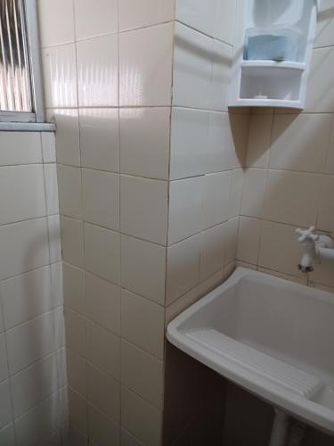 baño de azulejos blancos con lavabo y ventana en PRAIA DO FORTE a 5 Min de carro - PRAIA DAS DUNAS BRAGA a 7 Min a pé - WI FI en Cabo Frío