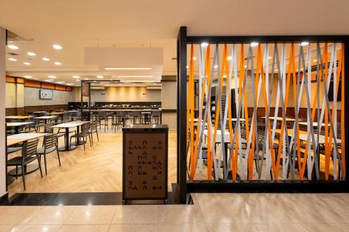 a restaurant with tables and chairs in a cafeteria at HUS Hotel MARINGA in Maringá