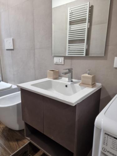 a bathroom with a sink and a toilet and a mirror at Casa Candio in Pavia