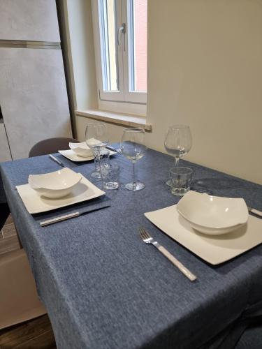 a table with plates and wine glasses on it at Casa Candio in Pavia