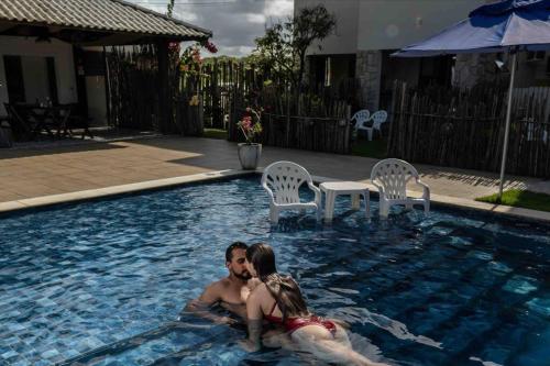 a man and a woman are in a swimming pool at Reserva do Paiva suites in Cabo de Santo Agostinho