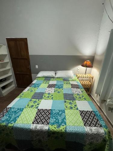 a bedroom with a bed with a quilt on it at Studio Morro das Pedras Floripa com Jacuzzi in Florianópolis