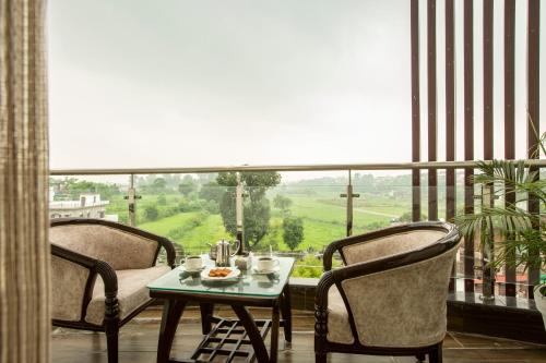 a room with a table and chairs and a large window at Eastlynn Resort Rishikesh in Rishīkesh