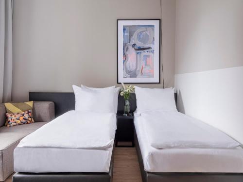 um quarto com duas camas e um sofá em numa I Bloc Rooms & Apartments em Frankfurt