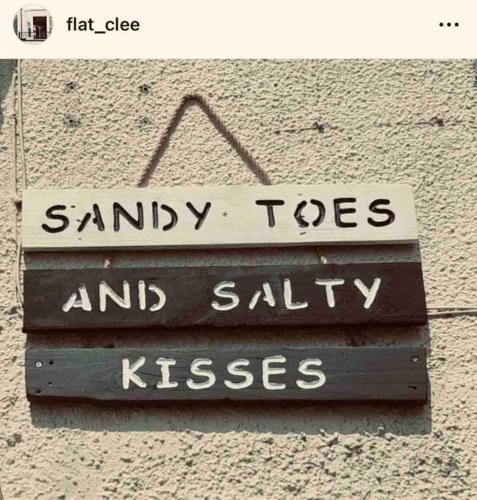 a sign that says sandy toes and salty kisses at Sea view Apartment Sandy Toes and Salty Kisses Sleeps upto 4 in Cleethorpes