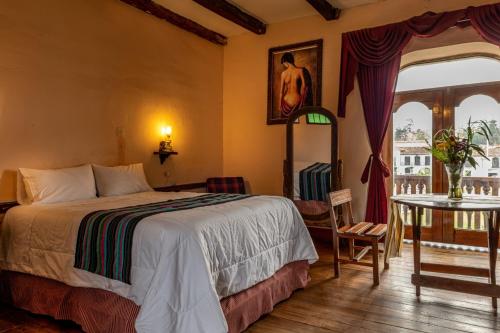 Schlafzimmer mit einem Bett, einem Tisch und einem Fenster in der Unterkunft Casona Del Rosario - Plaza de Armas in Chachapoyas