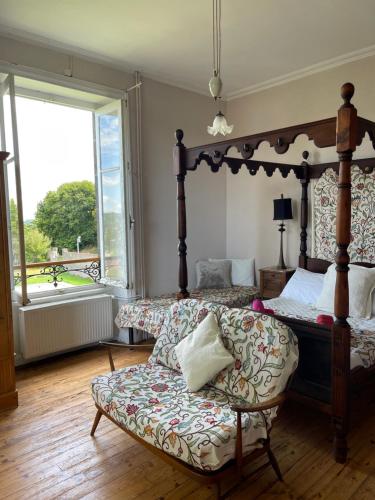 1 dormitorio con cama con dosel y sofá en Le Château Giat, en Giat
