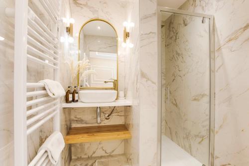 ein Bad mit einem Waschbecken und einem Spiegel in der Unterkunft Casa Gauda — Jacuzzi, relaxation & serenity in Falaise