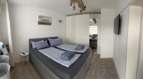 una camera da letto con un letto con cuscini blu di Dünenrose am Nordstrand a Norderney