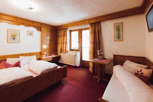 a hotel room with two beds and a television at Apart Himmel-Raich in Kaunertal