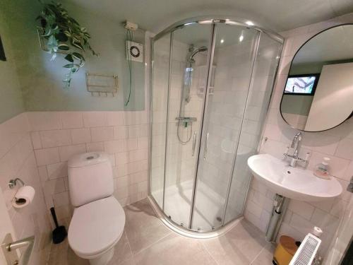 een badkamer met een douche, een toilet en een wastafel bij Verblijf midden in de natuur in de Jagershut! in Hattemerbroek