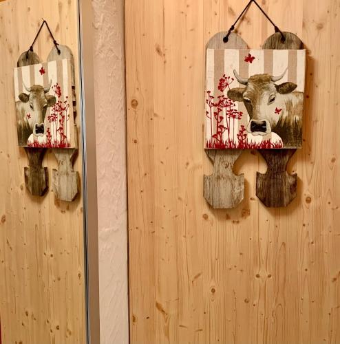 two pictures of cows are hanging on a wall at Le Gite de Briey - à 7 minutes de Vercorin in Chalais