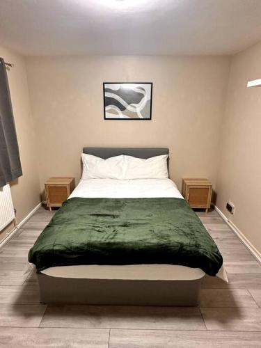 una camera da letto con un letto con una coperta verde sopra di Apartment in Greenwich a Londra