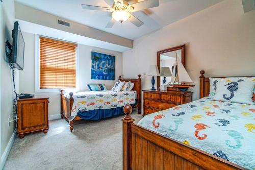 1 dormitorio con 2 camas y TV. en 4-bedroom condo, elevator, king bed, and parking, en Ocean City